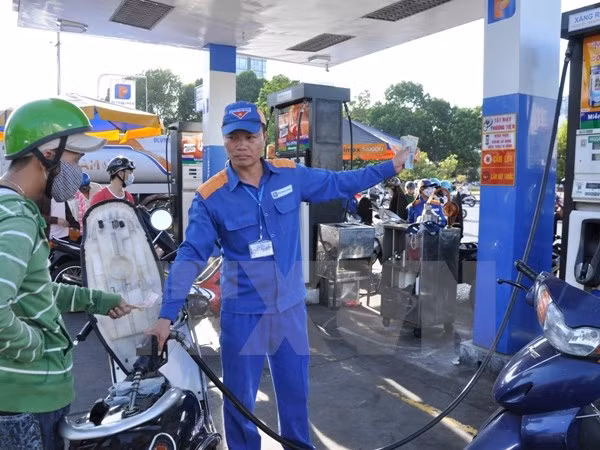 Nhân viên của Petrolimex đang bán xăng cho khách. Ảnh: TTXVN
