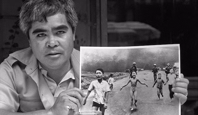 Phóng viên ảnh Nick Ut bên bức hình Em bé Napalm. Ảnh: VICE Phóng viên ảnh Nick Ut bên bức hình Em bé napalm. Ảnh: VICE