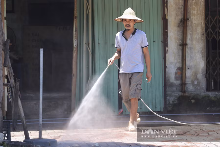 Một số người dân phải dùng đến vòi phun nước để hạ nhiệt trước cửa nhà.