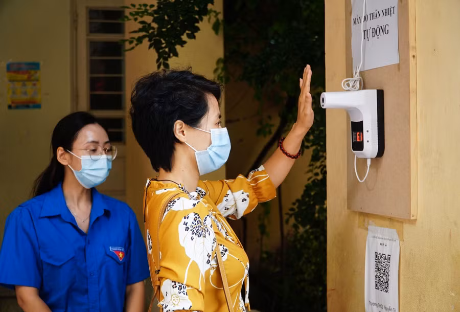 Phụ huynh đo thân nhiệt.