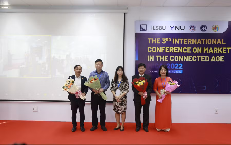Đại diện Trường ĐH Kinh tế, ĐH Đà Nẵng tặng hoa cho các đơn vị đồng tổ chức