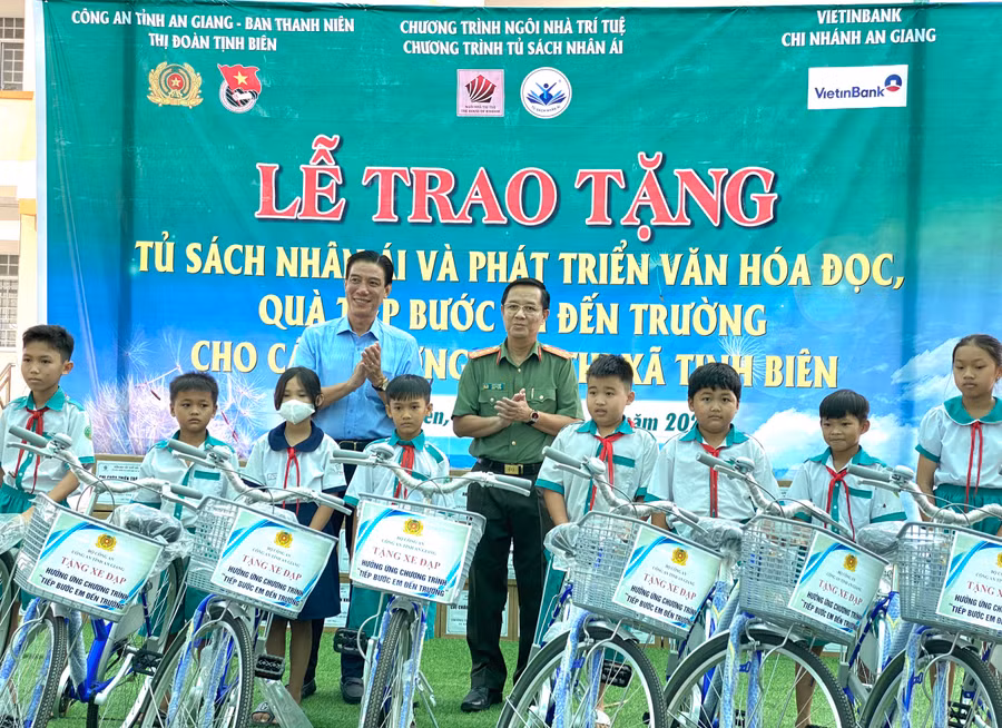 Đại tá Lê Phú Thạnh - Phó Giám đốc Công an An Giang cùng trao xe đạp cho học sinh khó khăn.