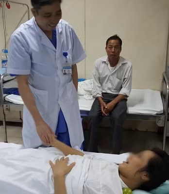 Tiến sĩ Vũ Bá Quyết thăm hỏi bệnh nhân sau ca mổ. Ảnh: Hà An. sp11-9426-1436609267.jpg