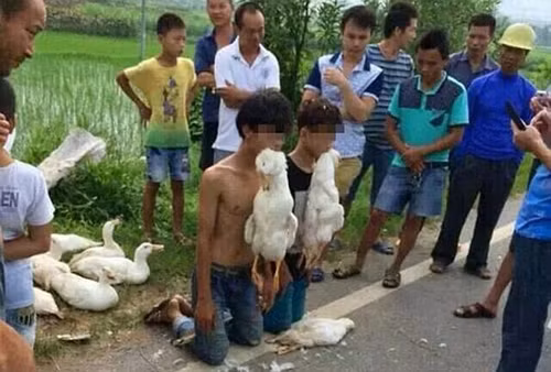 Dân làng bắt hai thiếu niên trộm ăn trộm quỳ xuống dưới sự chứng kiến của những người dân hiếu kỳ xung quanh. Sau đó họ còn bắt thủ phạm ngậm chặt hai con vịt đã chết trong miệng. vn2-JPG-2187-1409391916.jpg