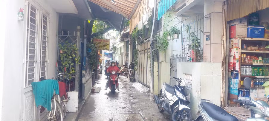 Lối vào Trường Mầm non Cẩm Vân chỉ đủ cho 2 xe máy tránh nhau do có nhiều hàng quán, người dân để xe máy hai bên đường.
