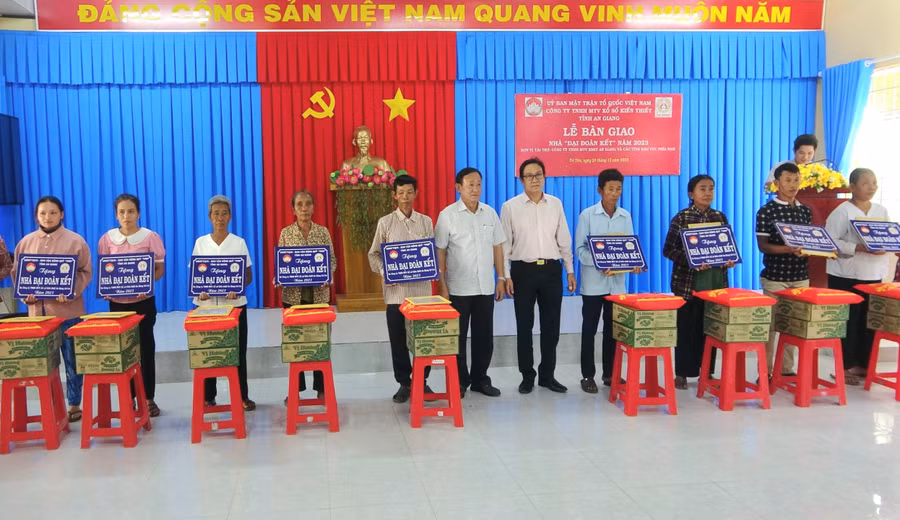 Ông Nguyễn Tiếc Hùng - Chủ tịch Ủy ban MTTQVN tỉnh An Giang và nhà tài trợ trao biểu trưng nhà và tặng quà cho hộ nghèo.