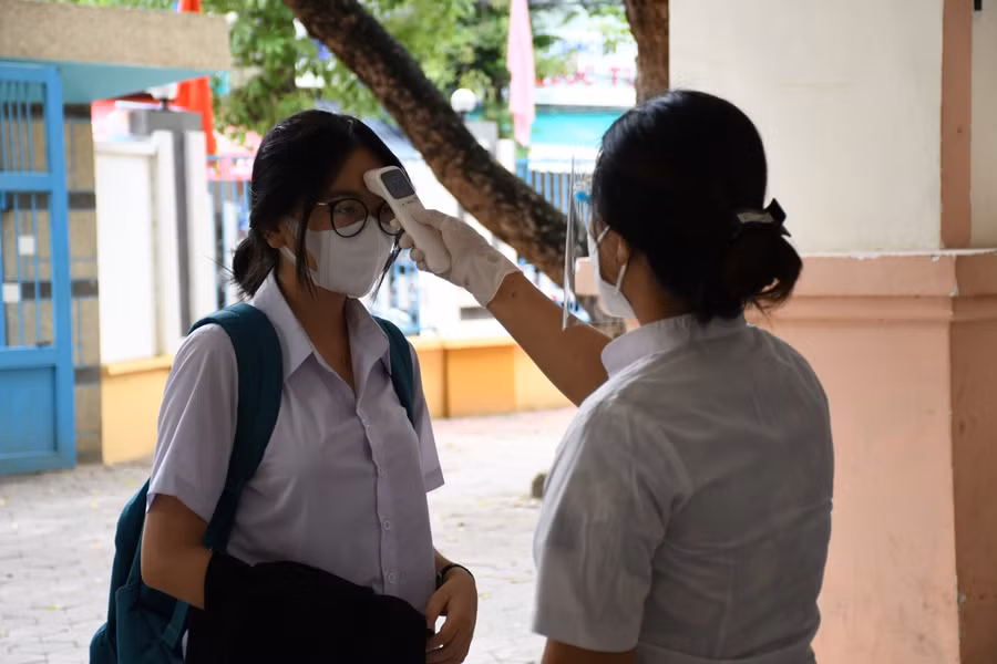Sau khi đo thân nhiệt, thí sinh được phân luồng về phòng thi, không tụ tập trong sân trường để đảm bảo yêu cầu phòng dịch