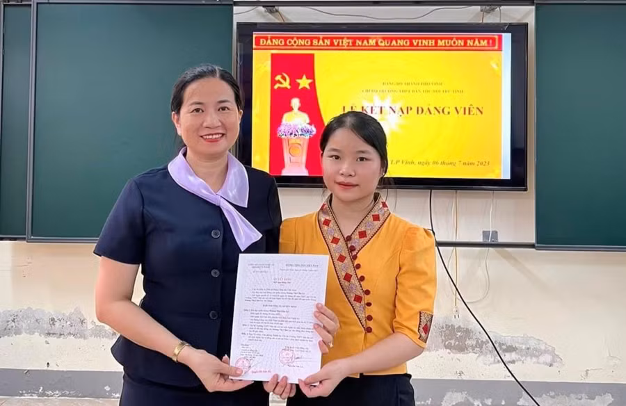 Cô Nguyễn Thị Kiều Hoa trao chứng nhận kết nạp Đảng cho học sinh. Ảnh NTCC