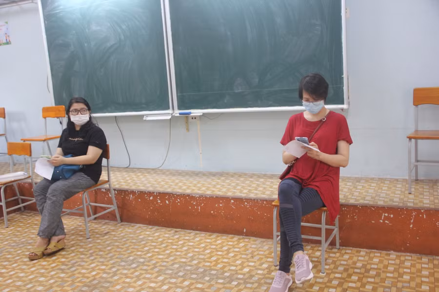 Sau khi tiêm vắc xin, giáo viên ngồi tại phòng chờ để theo dõi sức khoẻ