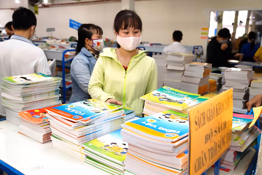 Phụ huynh tìm mua sách giáo khoa cho con trước thềm năm học mới. Ảnh: IT