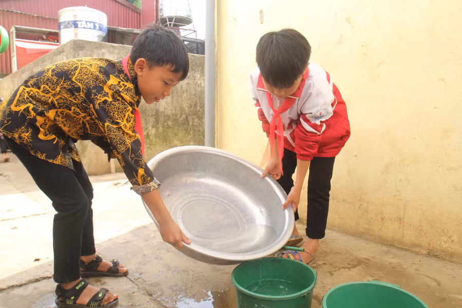 Học sinh Trường PTDTBT Tiểu học Hồng Thu tận dụng nước rửa tay để tưới hoa.