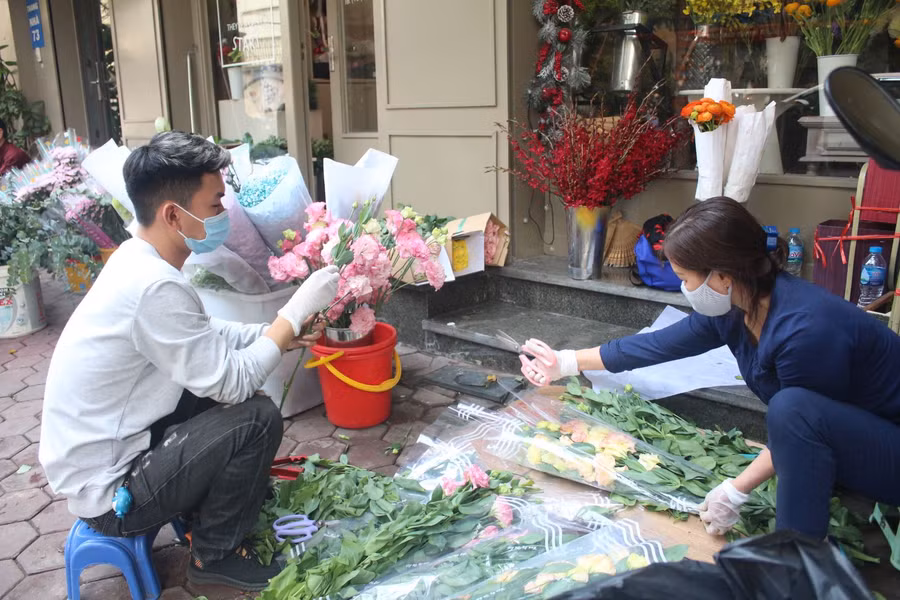 Nhân viên tại một cửa hàng hoa tất bật bó hoa cho khách.