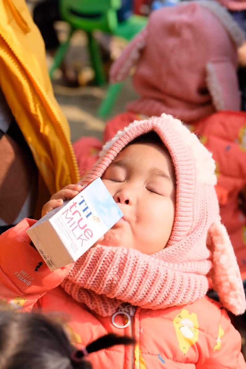 Các em nhỏ hạnh phúc uống ly sữa yêu thương.