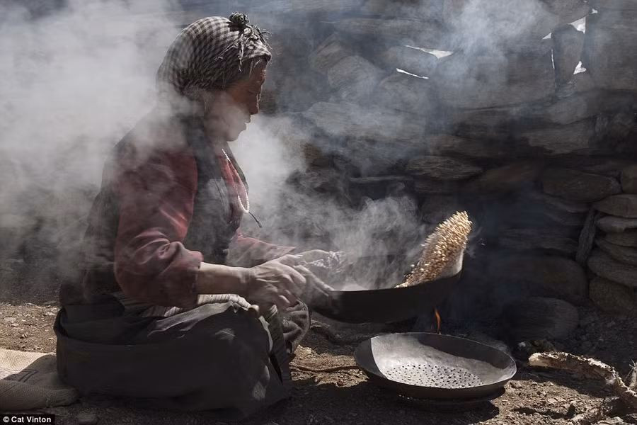 Bà Yangyen đang làm tsampa - một loại bột của Tây Tạng - từ đại mạch rang. Bà Yangyen đang làm tsampa - một loại bột của Tây Tạng - từ đại mạch rang.