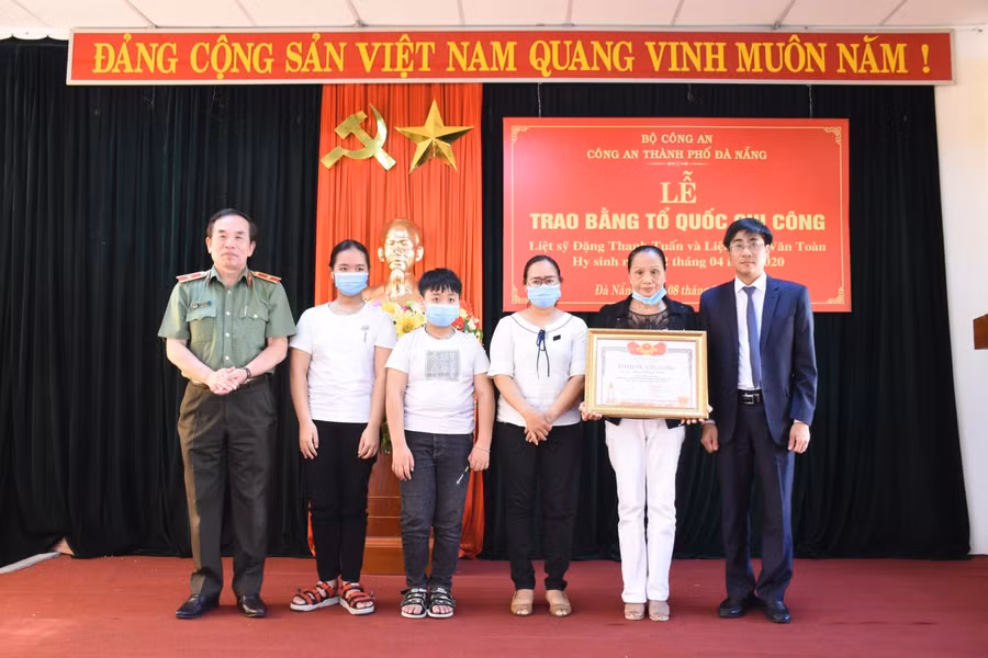 Ông Trần Thắng Lợi (ngoài cùng bìa phải) – Bí thư quận Sơn Trà và Thiếu tướng Vũ Xuân Viên – Giám đốc Công an TP Đà Nẵng (ngoài cùng, bìa trái), trao bằng Tổ quốc ghi công cho thân nhân liệt sỹ Thiếu tá Đặng Thanh Tuấn.