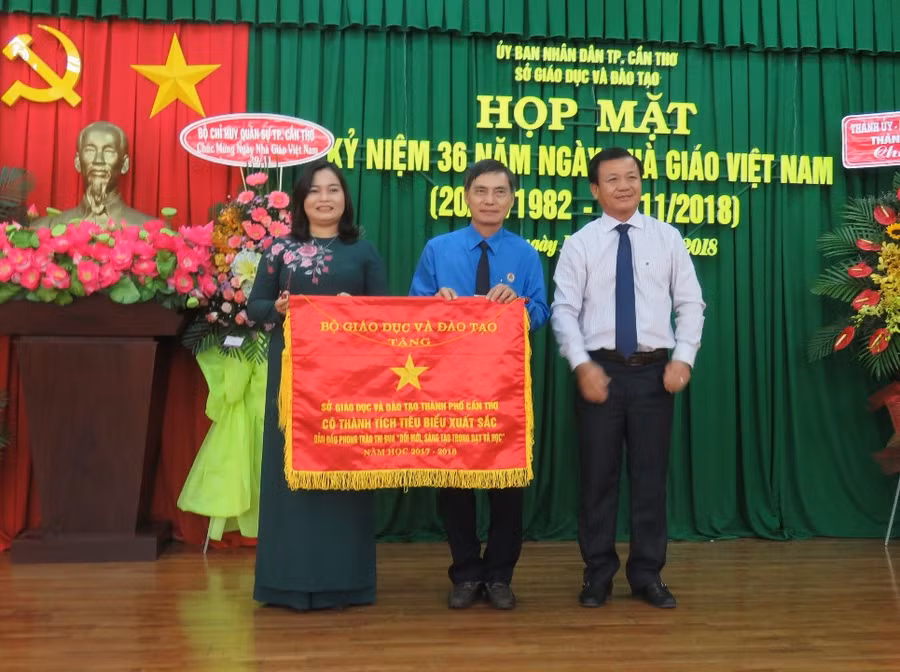 Bà Trần Hồng Thắm - GĐ Sở GD&ĐT TP Cần Thơ và ông Lương Hiển Vinh - Chủ tịch Công đoàn ngành nhận Cờ thi đua của Bộ GD&ĐT trao tặng