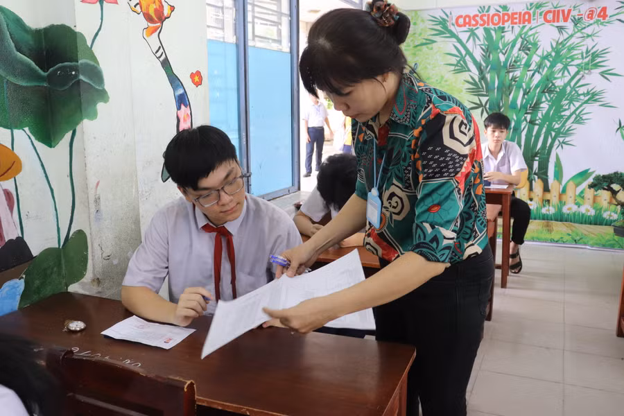 Cán bộ coi thi kiểm tra thông tin của thí sinh trước giờ thi môn Ngữ văn.