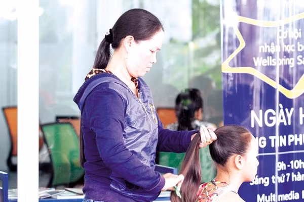 Một phụ huynh tranh thủ buộc lại tóc cho con trước khi bước vào phần thi vòng sơ tuyển Giọng hát Việt nhí tại Hà Nội. Ảnh: Duy Anh Giọng hát Việt nhí 2015: Những chuyện nhặt ở hậu trường