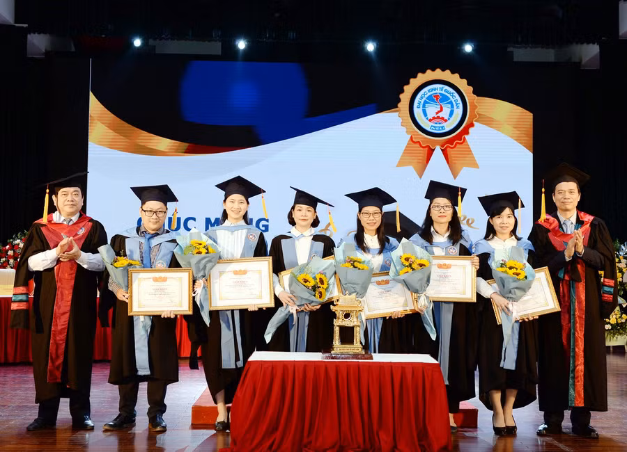 GS.TS Phạm Hồng Chương – Hiệu trưởng nhà trường và GS.TS Trần Thọ Đạt – Chủ tịch Hội đồng Khoa học và Đào tạo tặng hoa, giấy khen cho các tân Tiến sĩ có thành tích xuất sắc trong toàn khoá học.
