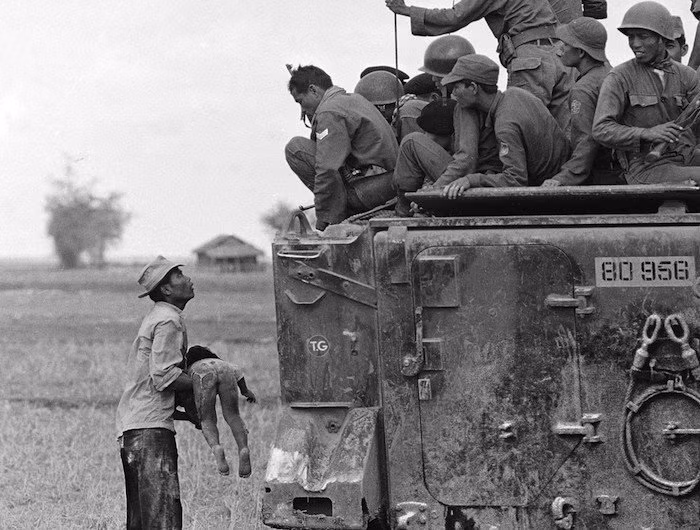 Một người đàn ông đang bế đứa con đã chết gần biên giới Campuchia ngày 19/3/1964.