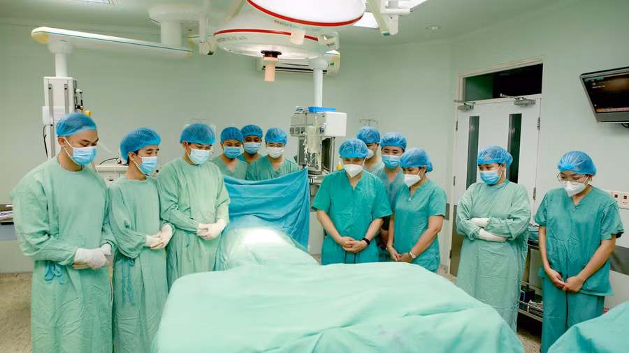 Tập thể bác sĩ bệnh viện Trung ương Huế cúi đầu tiễn biệt bệnh nhân.