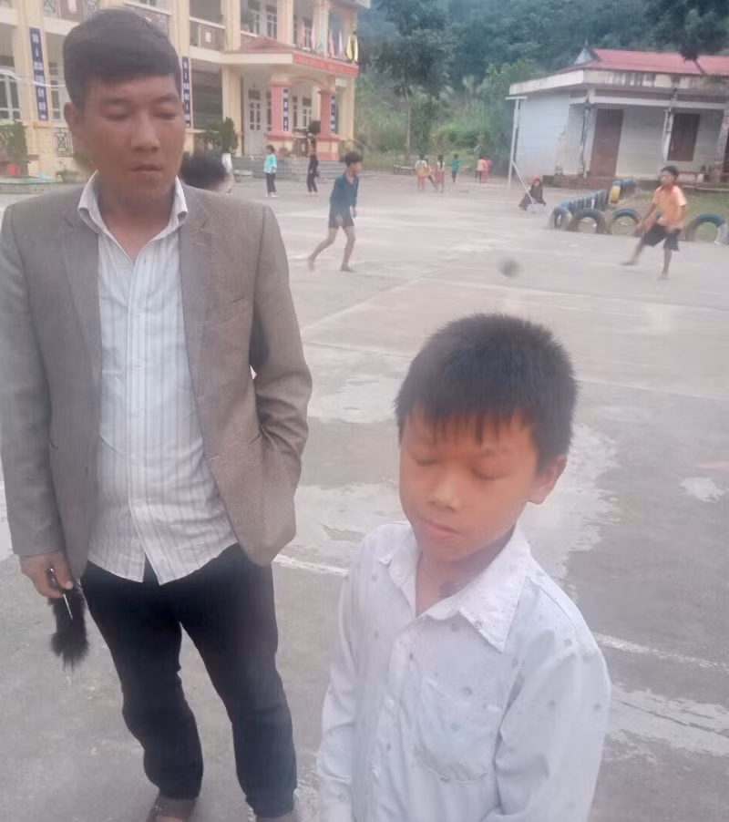 Hình ảnh cán bộ bản hỗ trợ đưa học sinh đến trường.