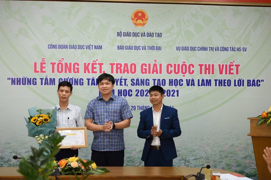 Ông Doãn Hồng Hà, Phó Vụ trưởng Giáo dục chính trị và Công tác học sinh, sinh viên trao phần thưởng Nhân vật tiêu biểu tới thầy giáo Vũ Xuân Quế - Hiệu trưởng Trường THCS và THPT Bát Xát, tỉnh Lào Cai, nhân vật trong tác phẩm “Người thầy mang bếp lửa đến vùng cao” của tác giả Trần Tuấn Ngọc.