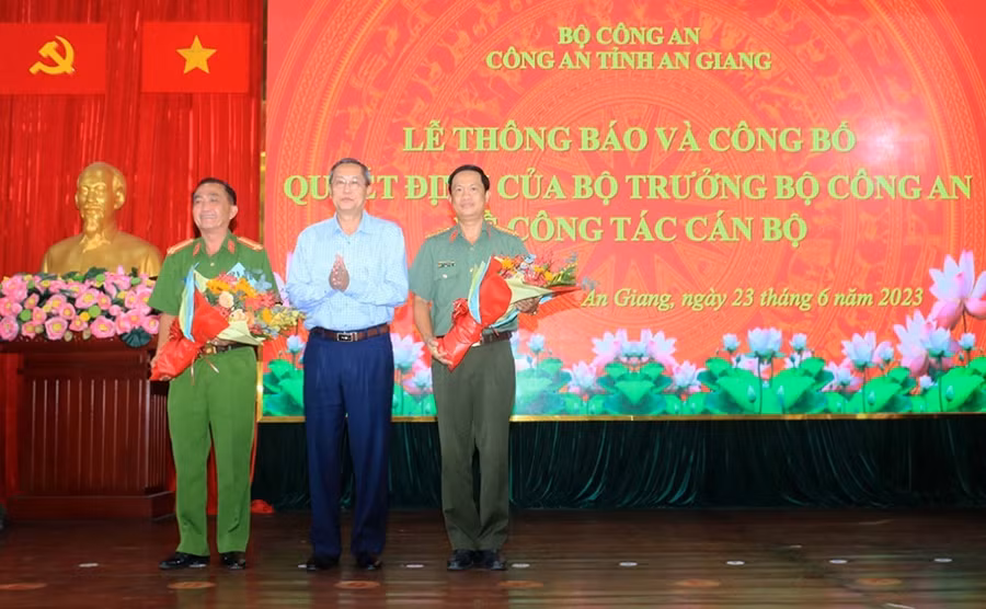 Ông Lê Văn Nưng - Phó Bí thư Thường trực Tỉnh ủy, Chủ tịch HĐND tỉnh An Giang tặng hoa cho đại tá Bùi Bé Năm và đại tá Nguyễn Nhật Trường. (Ảnh: Tiến Tầm)