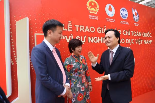 Bộ trưởng Phùng Xuân Nhạ trao đổi với lãnh đạo Báo Giáo dục và Thời đại bên lề lễ trao giải Báo chí toàn quốc "Vì sự nghiệp giáo dục" 2019. Ảnh: Xuân Phú