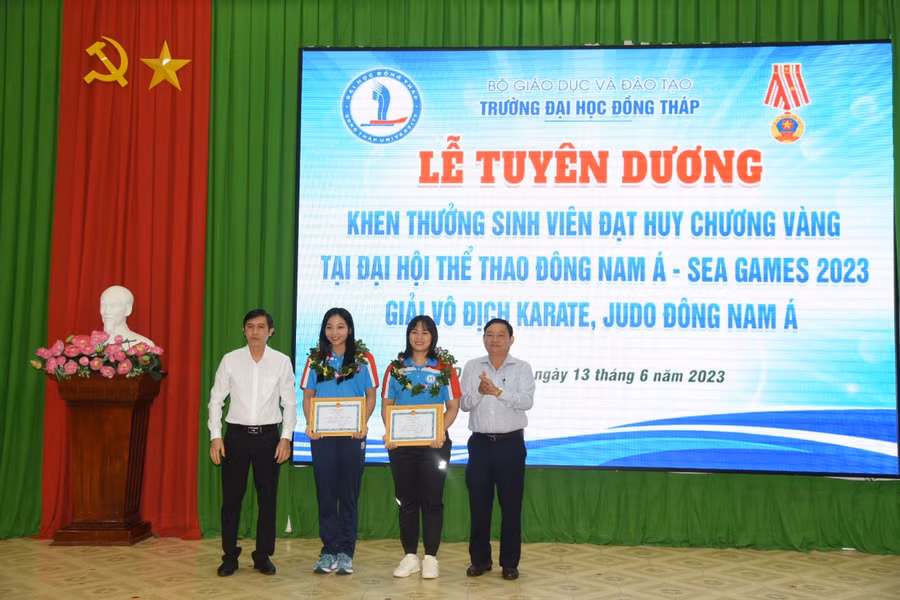 TS Trương Tấn Đạt - Bí thư Đảng ủy, Chủ tịch Hội đồng trường (trái) và TS Hồ Văn Thống - Hiệu trưởng trao khen thưởng cho sinh viên.