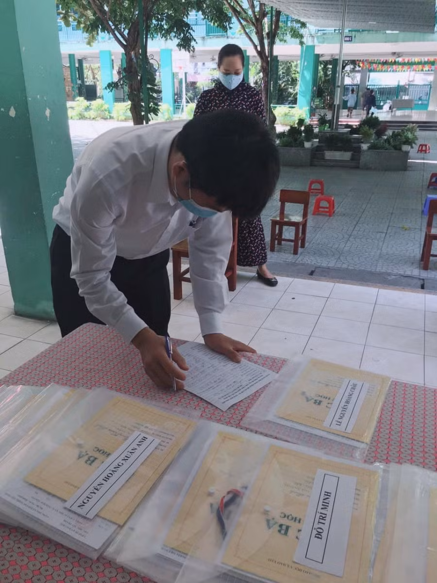 Phụ huynh Trường Tiểu học Núi Thành đến trường nhận hồ sơ và học bạ cho HS lớp 5. HS khối lớp 5 sẽ không có Lễ ra trường như mong đợi do ảnh hưởng bởi dịch bệnh