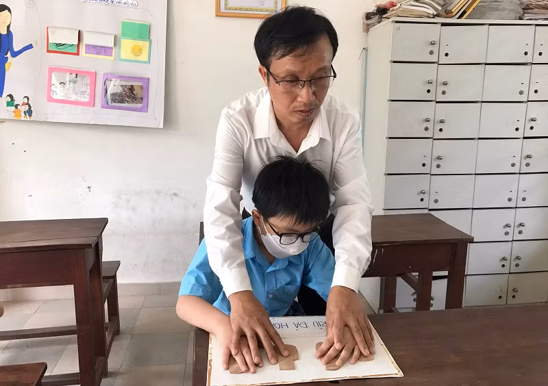 Thầy Khương hướng dẫn học sinh bị khiếm thị học môn Lịch sử.
