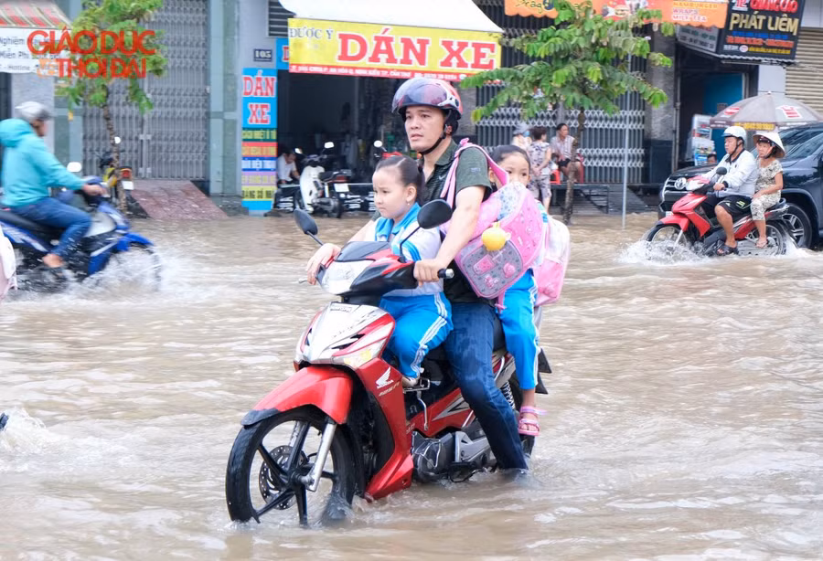 Nước ngập khiến việc đưa con đi học hết sức vất vả.