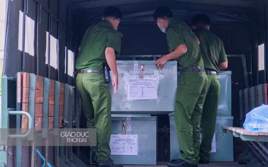 Lực lượng công an xếp các thùng chứa đề thi cẩn thận, bảo vệ nghiêm ngặt.