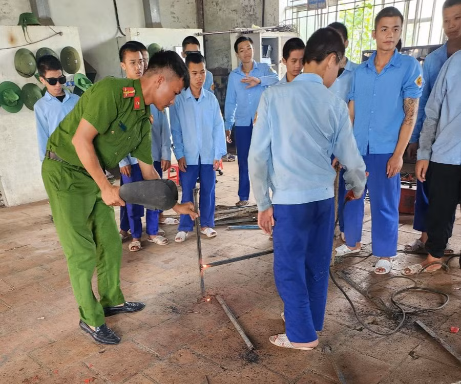 Đại úy Trần Đại Lượng dạy các em học nghề làm cửa nhôm kính. Ảnh: Khánh Toàn