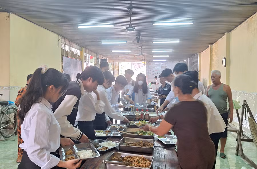 Các cô, chú Ban Từ thiện cùng các thí sinh chuẩn bị các suất cơm trưa. (Ảnh: Trọng Nhân)