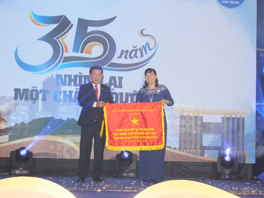 Ông Trần Thanh Liêm- Chủ tịch UBND tỉnh Bình Dương trao cờ thi đua của Bộ GD&ĐT cho đại diện lãnh đạo Sở GD&ĐT