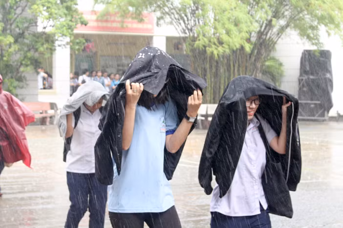 Không mang dù theo nên các em dùng áo khoác để che mưa Không mang dù theo nên các em dùng áo khoác để che mưa