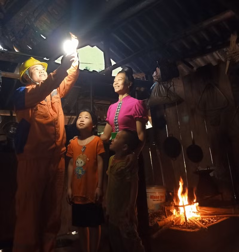 Công nhân ngành Điện lực hỗ trợ người dân lắp đặt bóng đèn.