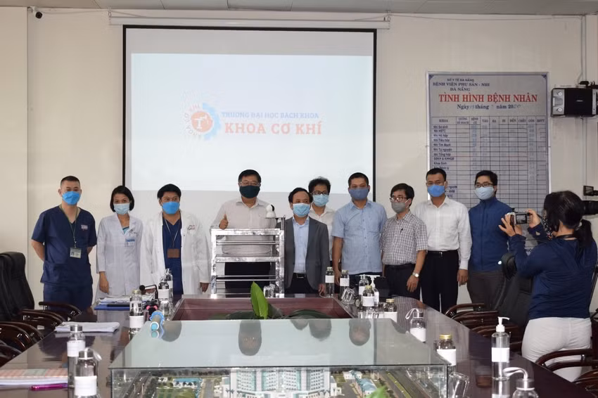 Robot vận chuyển thức ăn phục vụ người cách ly vì dịch Covid–19 của thầy, trò Trường ĐH Bách khoa, ĐH Đà Nẵng được tri ân “Tuyến đầu chống dịch Covid-19. Trong ảnh: Đại diện lãnh đạo Trường ĐH Bách khoa và bệnh viện Phụ Sản nhi Đà Nẵng tại buổi Lễ bàn giao Robot BK-ANTICOVID vào tháng 3/2020.