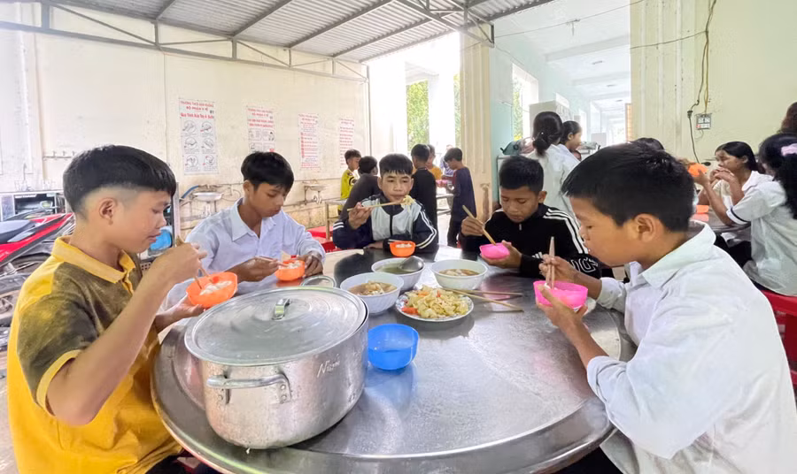 Học sinh làng Kon Tủ ăn uống ngon lành với bữa cơm tự nấu.