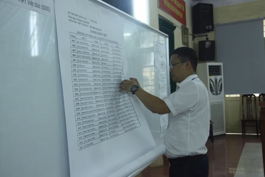Thư ký điểm thi dán danh sách cán bộ coi thi.
