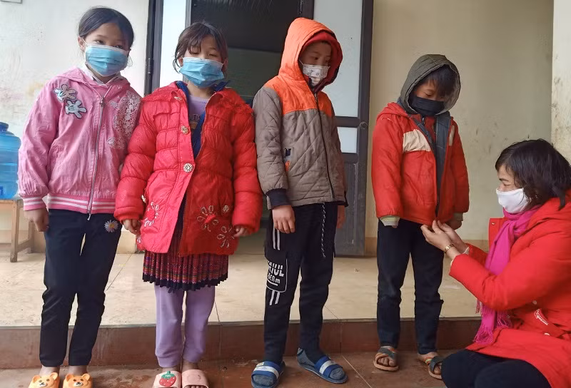 Cô Hoàng Thị Oánh tận tay mặc áo ấm cho học sinh.