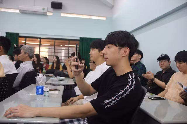 Một sinh viên dùng điện thoại ghi lại hướng dẫn của các chiến sĩ công an giao thông trong buổi nói chuyện Một sinh viên dùng điện thoại ghi lại hướng dẫn của các chiến sĩ công an giao thông trong buổi nói chuyện