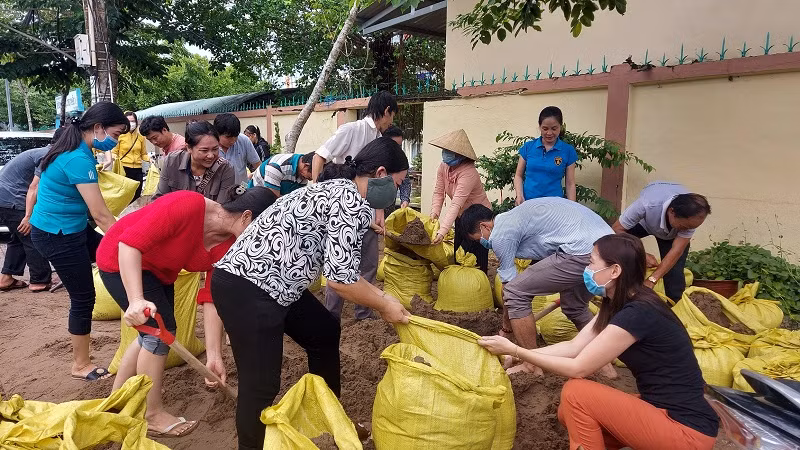 Thầy cô giáo Trường Tiểu học Thị trấn 1, huyện Vĩnh Thuận (Kiên Giang) gia cố trường học bằng bao cát để kịp đón HS trở lại lớp.