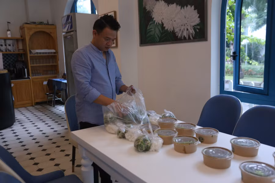 Anh Nguyễn Sơn Tùng - chủ khách sạn Santori (TP Đà Nẵng) chuẩn bị những bữa ăn cho người dân khi trú bão tại đây.