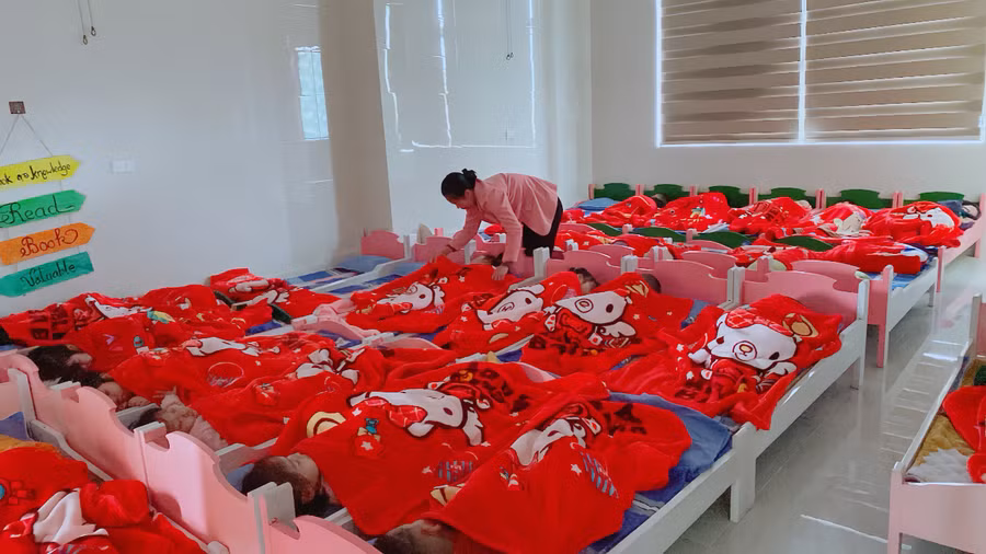 Giáo viên Trường Mầm non Bắc Hà (TP Hà Tĩnh) giữ ấm cho trẻ trong giờ ngủ trưa.