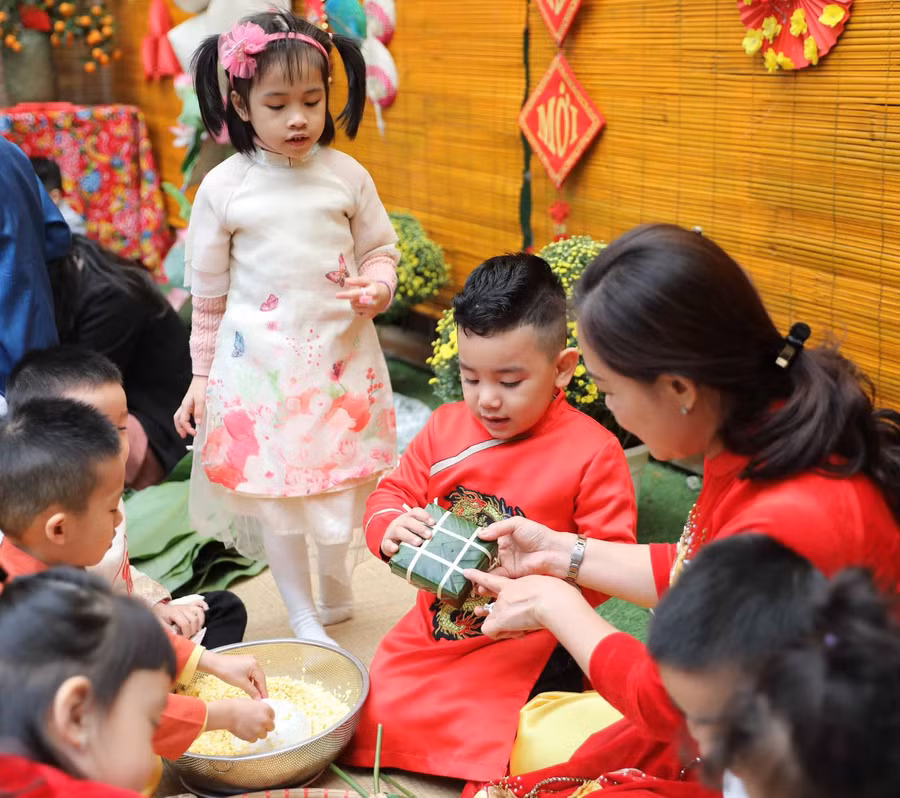 Cô giáo Trường Mẫu giáo Mầm non A hướng dẫn học sinh gói bánh chưng. Ảnh: TG Cô giáo Trường Mẫu giáo Mầm non A hướng dẫn học sinh gói bánh chưng. Ảnh: TG