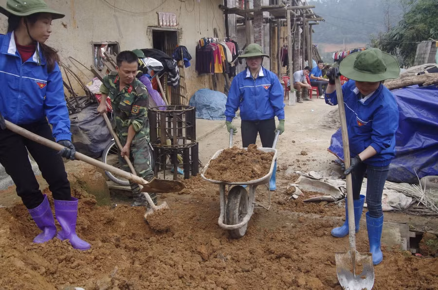 Thanh niên tình nguyện Nông lâm trường 196, Đoàn Kinh tế - Quốc phòng 338 giúp nhân dân thôn Co Chí, xã Xuất Lễ (Cao Lộc, Lạng Sơn) làm đường bê tông. Ảnh: baodantoc.vn