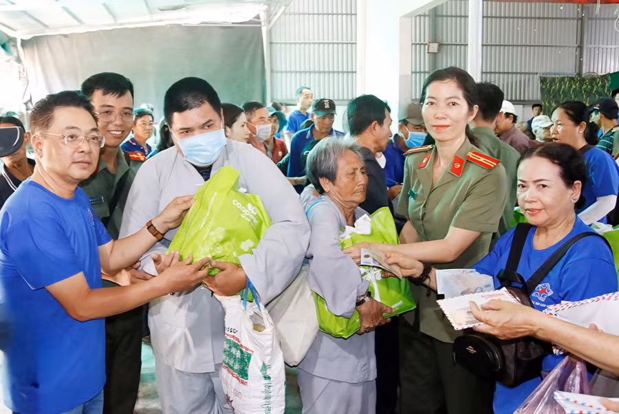 Lực lượng Công an và Nhóm thiện nguyện trao quà cho người dân.